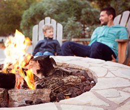 Father and son sitting by fire pit