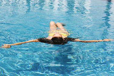 woman floating in swimming pool