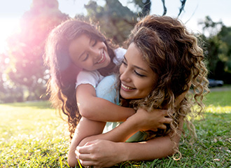 mother and daughter lying in the grass